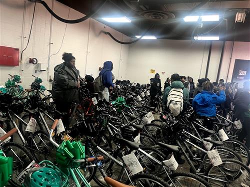 students standing with backpacks surrounded by black bikes